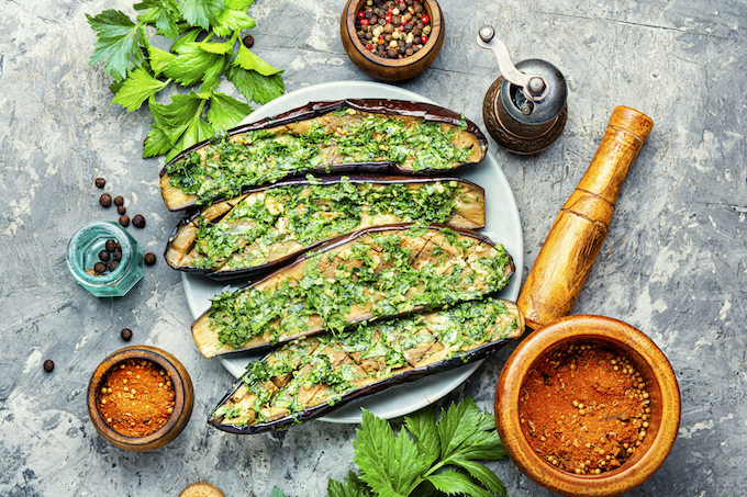 Halved homemade eggplant with garlic and parsley.Fried eggplant with herbs.Vegetarian food.